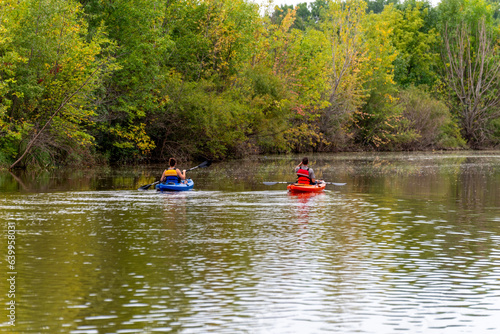 A Couple Kayaking On The River In Early September In Wisconsin