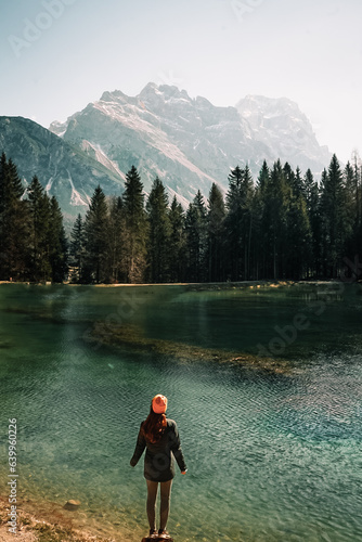Woman standing at an alpine lake during a cold sunny morning