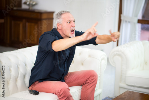 Картината върху платно Emotional supporter watching his favorite team playing while at home