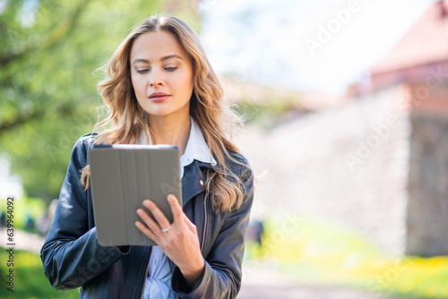 Woman using a tablet in the park photo