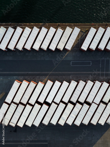 Aerial view looking straight down at shipping containers on the quayside next to the waters edge at Tilbury Docks, near London, UK.