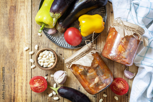 Healthy homemade fermented food. Salad eggplant with beanson a rustic table. Home economics, autumn harvest preservation. View from above. photo