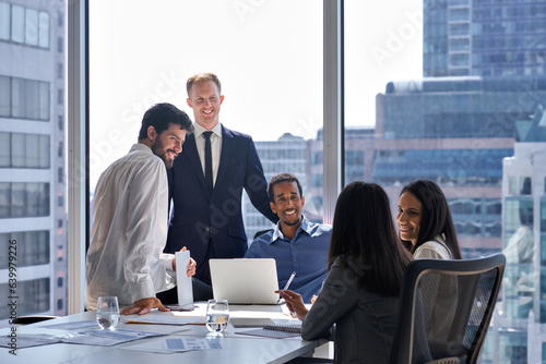 Professional happy diverse team business people talking at office meeting. Relaxed friendly international company workers executives group having teamwork discussion in board room at table.