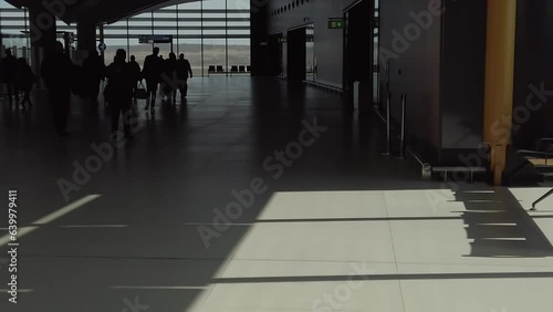 Slow motion footage of people going from plane to passport control zone at airport arrival area