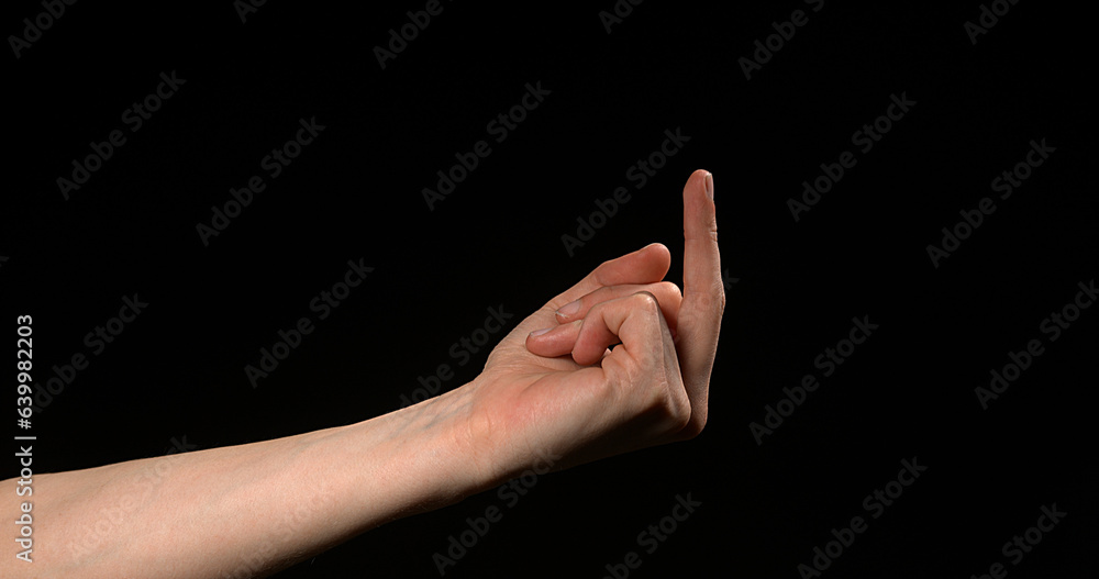 Hand of Woman making Sign against Black Background Hand of Woman making Sign against Black Background