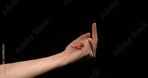 Hand of Woman making Sign against Black Background