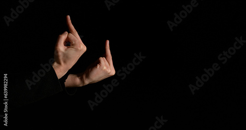 Hand of Woman making Sign against Black Background