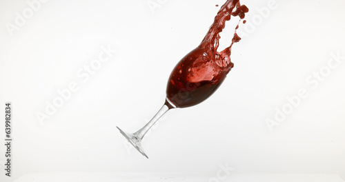Glass of Red Wine Falling and Splashing against White Background