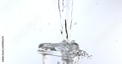 Water being poured into Glass against White Background