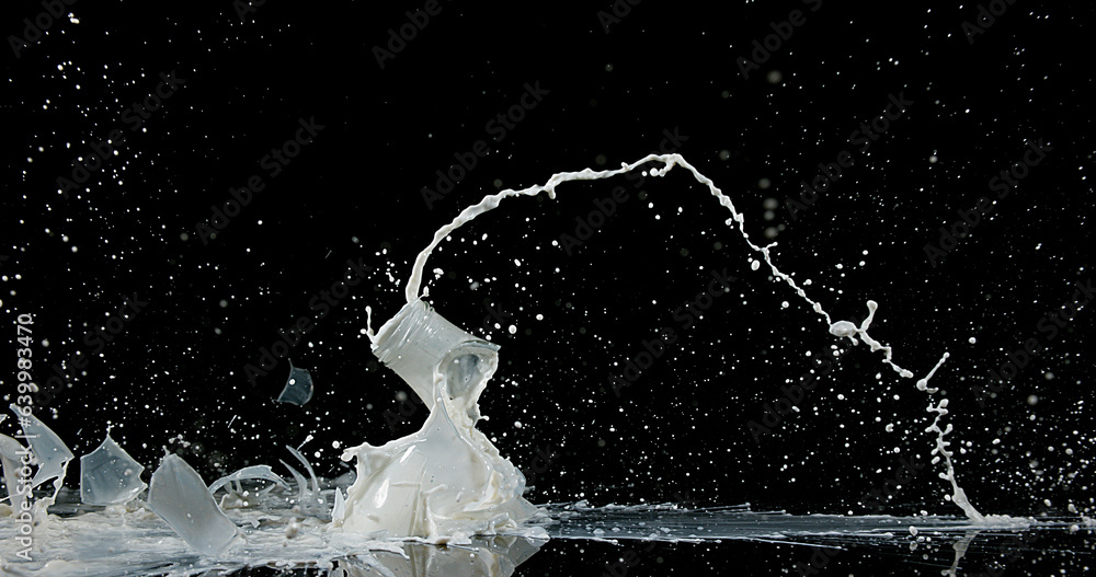 Obraz na płótnie Bottle of Milk Falling and Exploging against Black Background w salonie