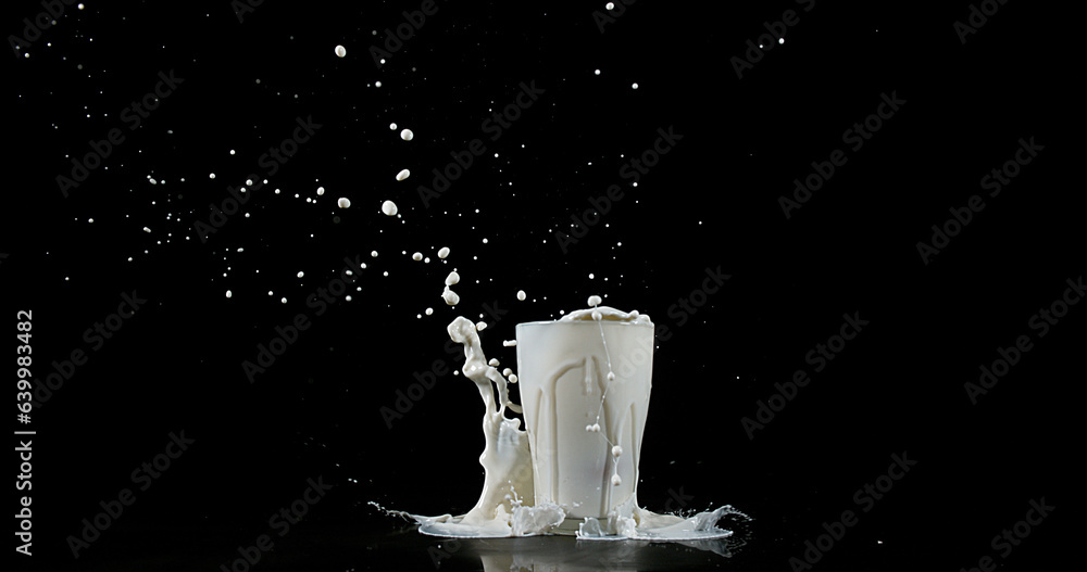 Glass of Milk Exploding against White Background Glass of Milk Exploding against White Background