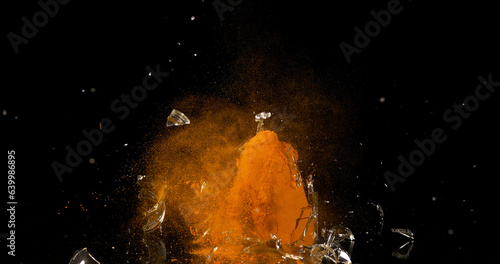 Turmeric, curcuma longa, Powder in a Small Jar Exploding against Black Background, Indian Spice