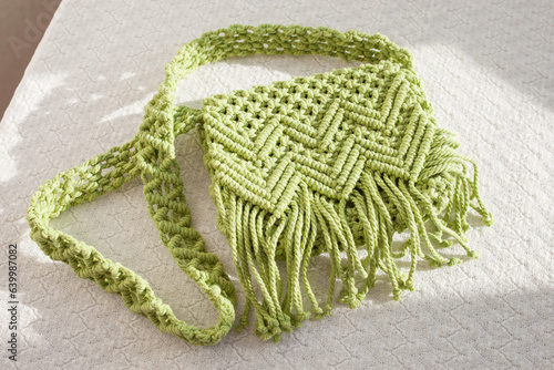 Handmade macrame cotton сross-body bag. Eco bag for women from cotton rope. Scandinavian style bag.  Light green color, sustainable fashion accessories. Details. Close up image