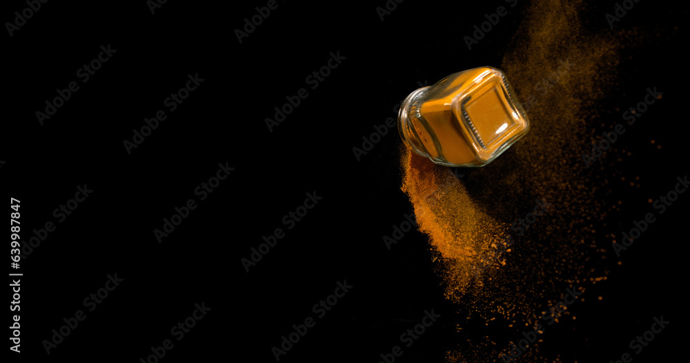 Turmeric, curcuma longa, Powder into a small jar falling against Black Background, Indian Spice Turmeric, curcuma longa, Powder into a small jar falling against Black Background, Indian Spice