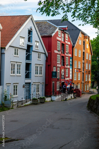 Street with old wooden houses and flags in the city of Trondheim, Norway.