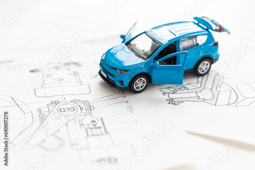 Toy car, black ink pen and documents on table. Toy sports car and pen on the form for the inspection of the car. Car inspection concept