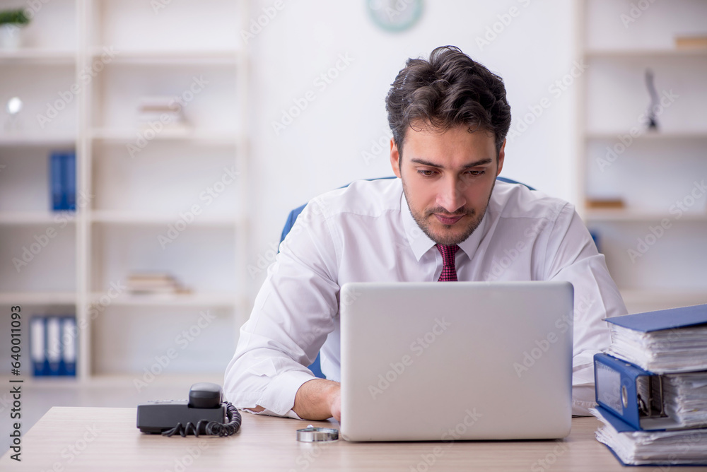 Young male employee working in the office Young male employee working in the office