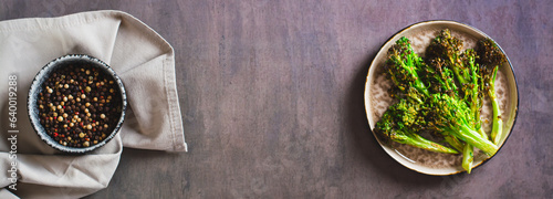 Roasted fresh broccoli sprouts in oil on a plate on the table top view web banner