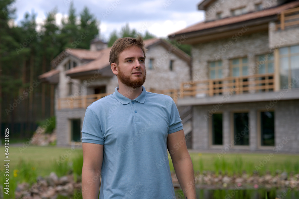 Portrait of happy young man standing in the garden outside his luxury home and smiling and relax outside Portrait of happy young man standing in the garden outside his luxury home and smiling and relax outside