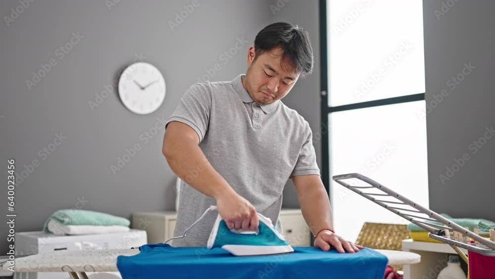 smiling confident ironing clothes at laundry room smiling confident ironing clothes at laundry room