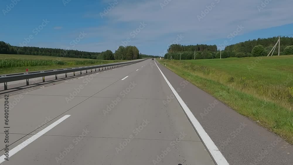 The car drives along the road on a summer day. Highways, roadside and road line markings. The car drives along the road on a summer day. Highways, roadside and road line markings.