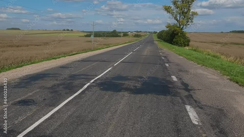The car drives along the road on a summer day. Highways, roadside and road line markings. The car drives along the road on a summer day. Highways, roadside and road line markings.
