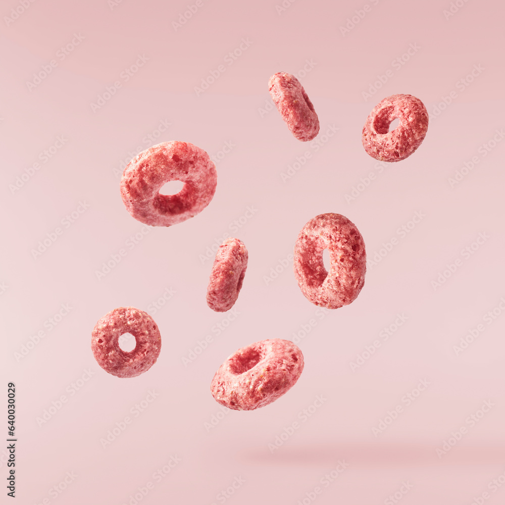 Fototapeta premium Tasty pink ring Cereals falling in the air isolated