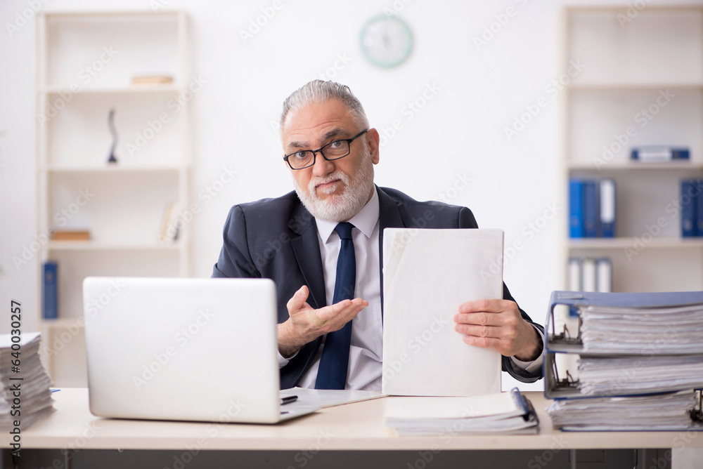 Old male employee working in the office Old male employee working in the office
