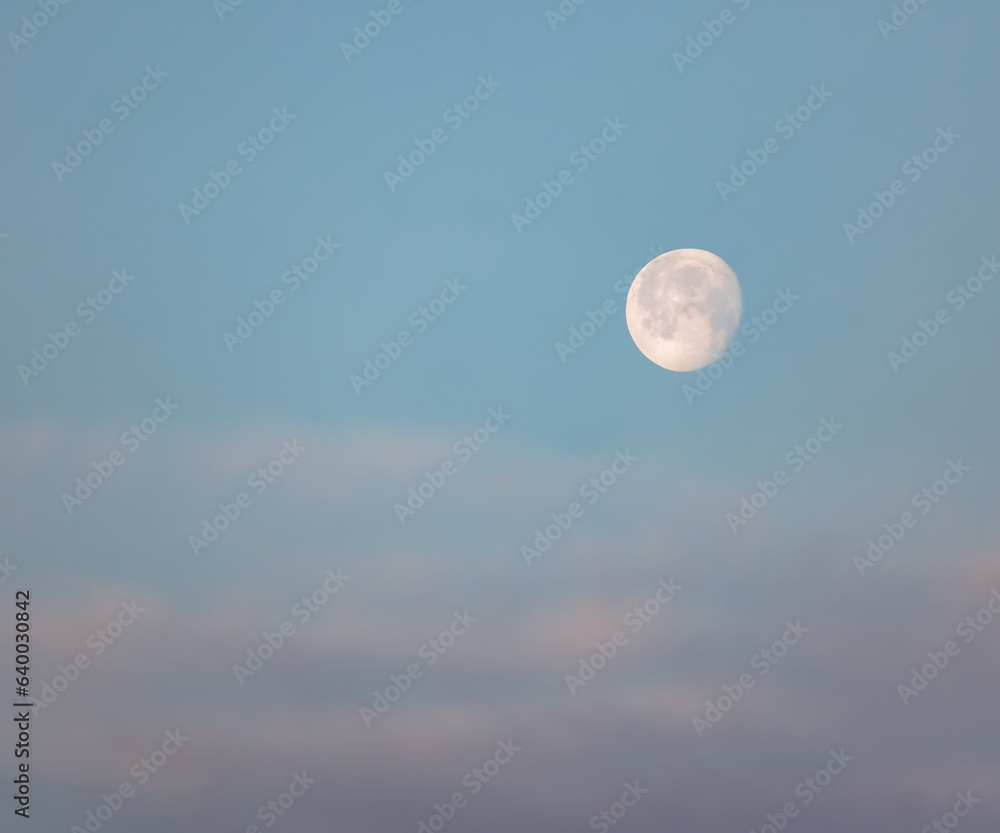 Lonely bright moon in the morning cloudy blue sky, moonlit morning in the desert Lonely bright moon in the morning cloudy blue sky, moonlit morning in the desert