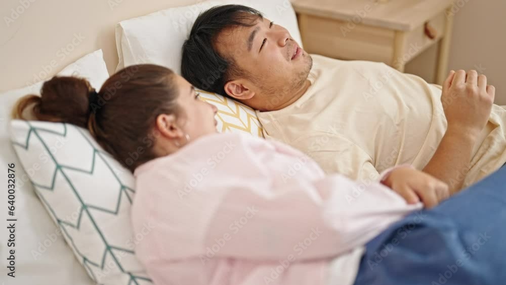 Man and woman couple lying on bed speaking at bedroom Man and woman couple lying on bed speaking at bedroom