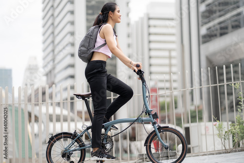 Eco friendly vehicle. 20s businesswoman ride bicycle to work in urban. Cycling has no pollution , alternative commute to global warming. Environmental preservation by sustainable energy with bicycling