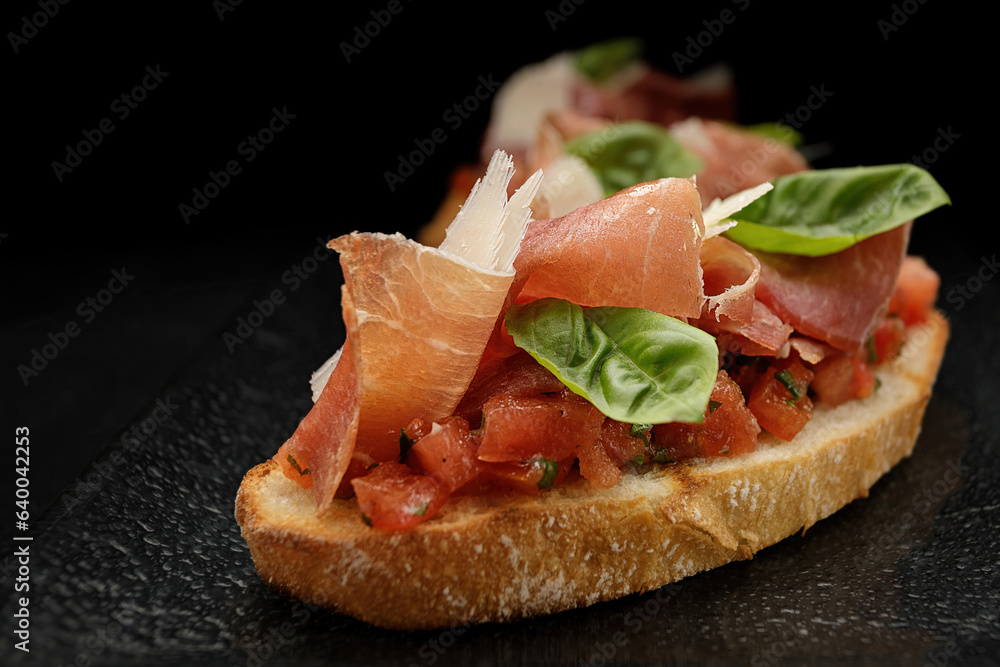 Savory Bruschetta with Salmon, Ham and Parmesan Cheese on Dark Background