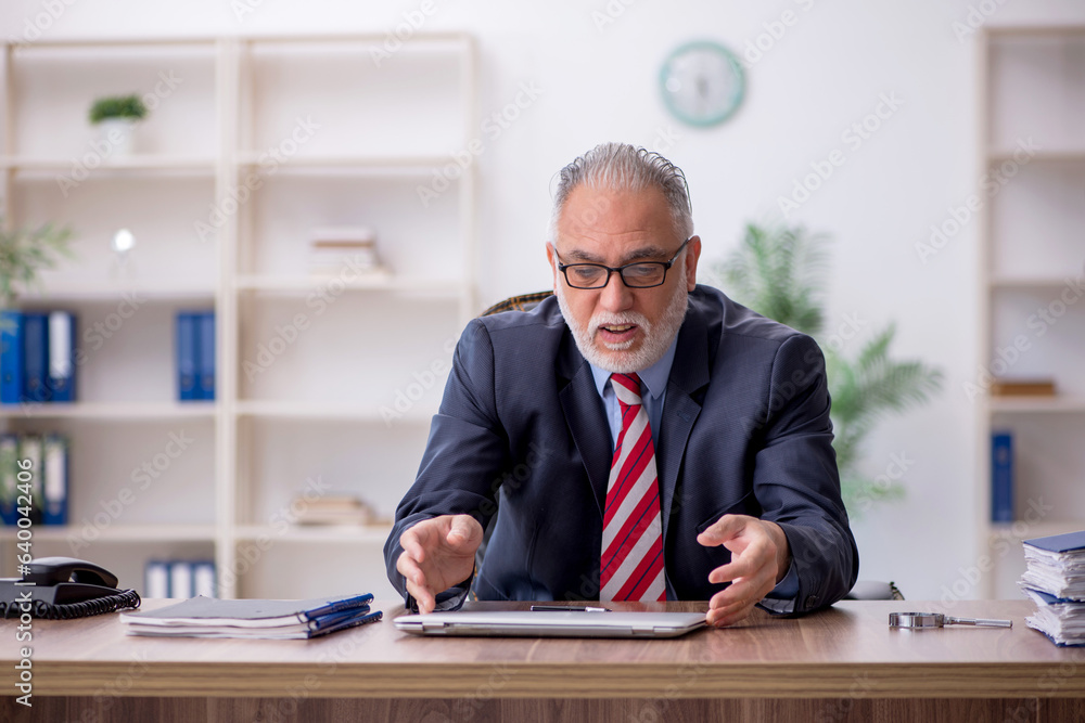Old male employee working in the office Old male employee working in the office