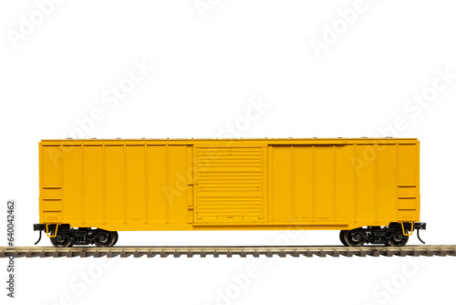 A yellow railroad box car with closed door on train track.