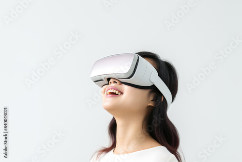 Young woman wearing virtual reality VR glasses, VR headset and trying to touch something with her hand while standing on white background.