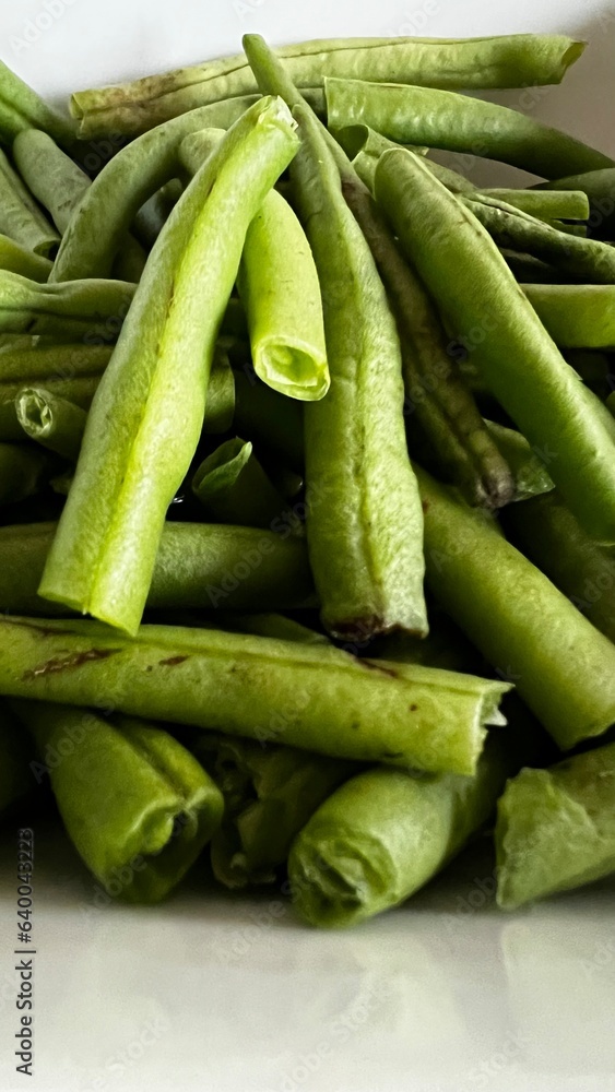 Macro shot closeup of fresh green beans out of the garden and stacked in a pile and cut into pieces Macro shot closeup of fresh green beans out of the garden and stacked in a pile and cut into pieces