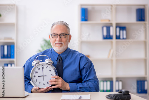 Old male employee in time management concept