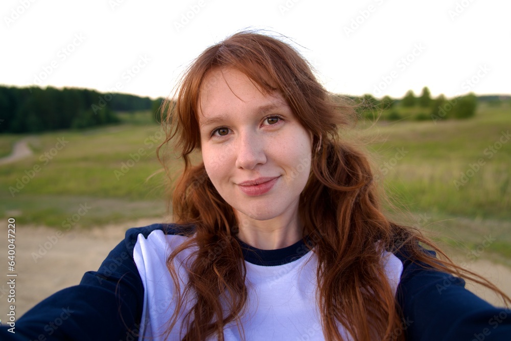 happy girl in the field in summer at sunrise or sunset, enjoying nature