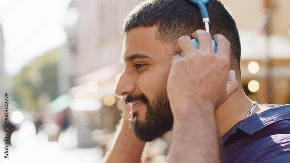 Profile of happy overjoyed indian young man wearing wireless headphones ...