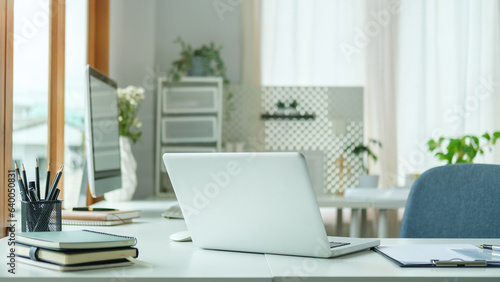 Modern workplace with laptop computer ,pencil holder and notebook on white table. © wattana