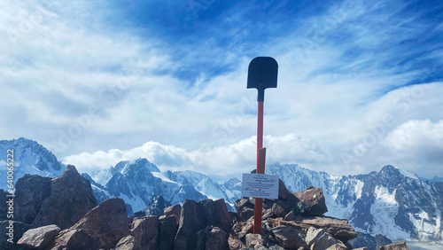 View of the top of Uchitel Peak in the mountains of Kyrgyzstan. A shovel in the rocks. Ala Archa National Park. Active summer vacation. photo