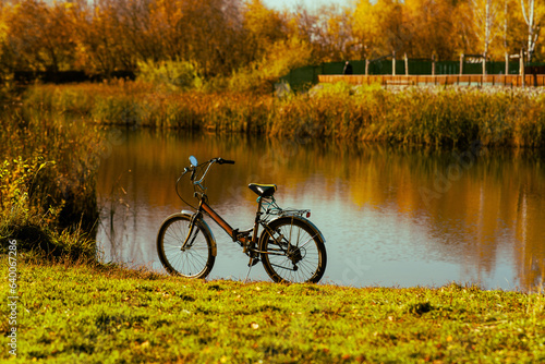 Autumn landscape of the park with a bike on lake