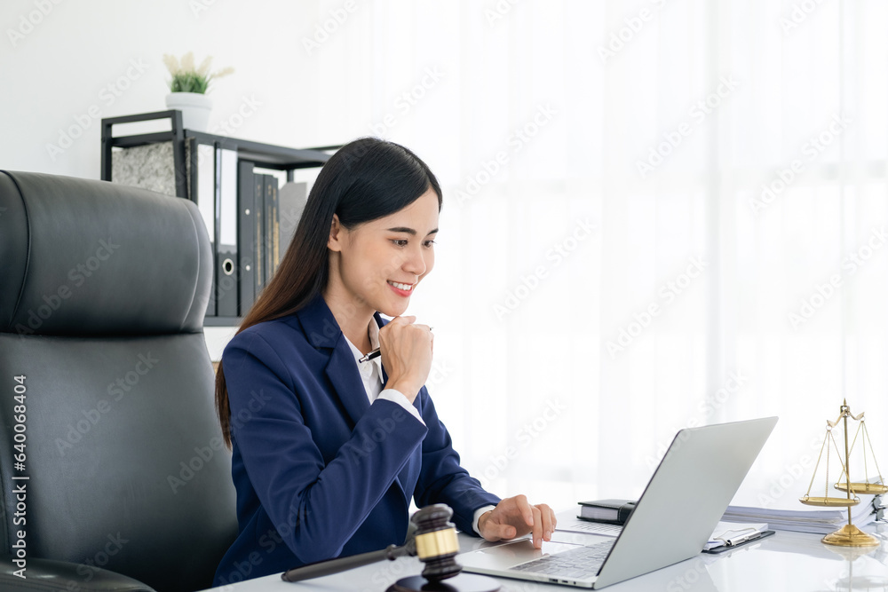 Justice and law concept. smiling Female lawyer in office with the gavel working with digital tablet computer docking keyboard on white table. Justice and law concept. smiling Female lawyer in office with the gavel working with digital tablet computer docking keyboard on white table.