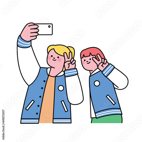 Festival. Two female students wearing baseball jackets are taking a selfie together.
