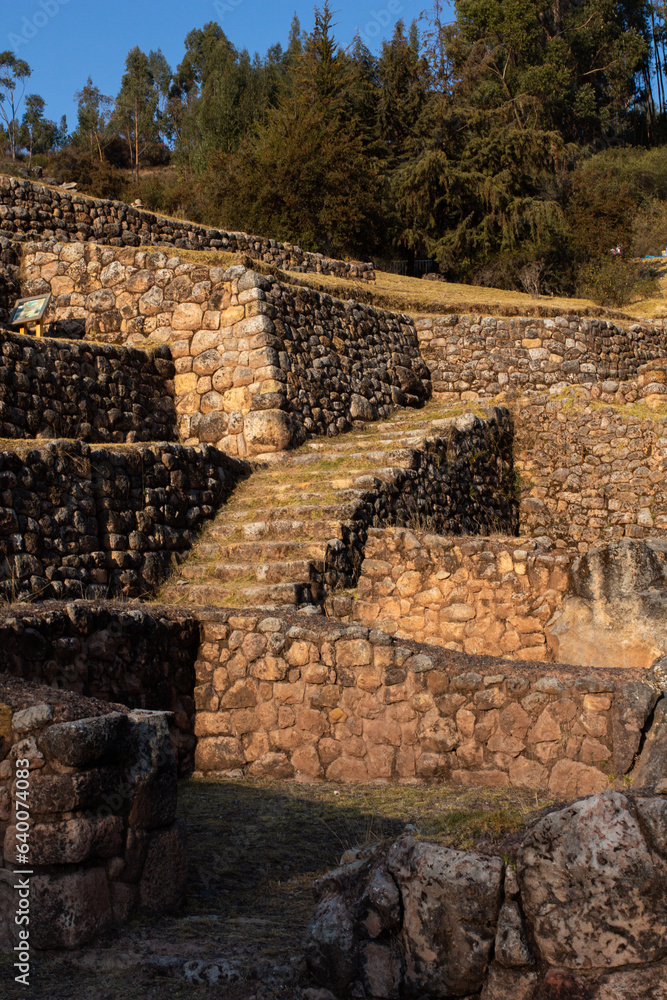 Inkilltambo, zona arqueológica incaica en Cusco, Perú, hecha de rocas y andenes antiguos en el atardecer.