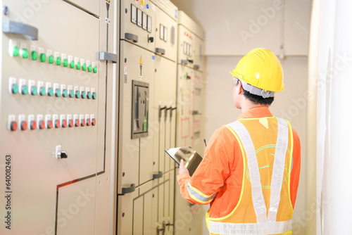 Smart Female Maintenance Engineer using digital tablet and standing in front of control room,Close up hand of engineer or electrician man working check the electrical system with tablet