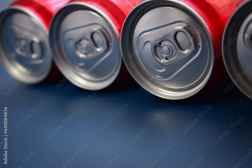 close up group of aluminium red cans soft drink put on blue texture background close up group of aluminium red cans soft drink put on blue texture background