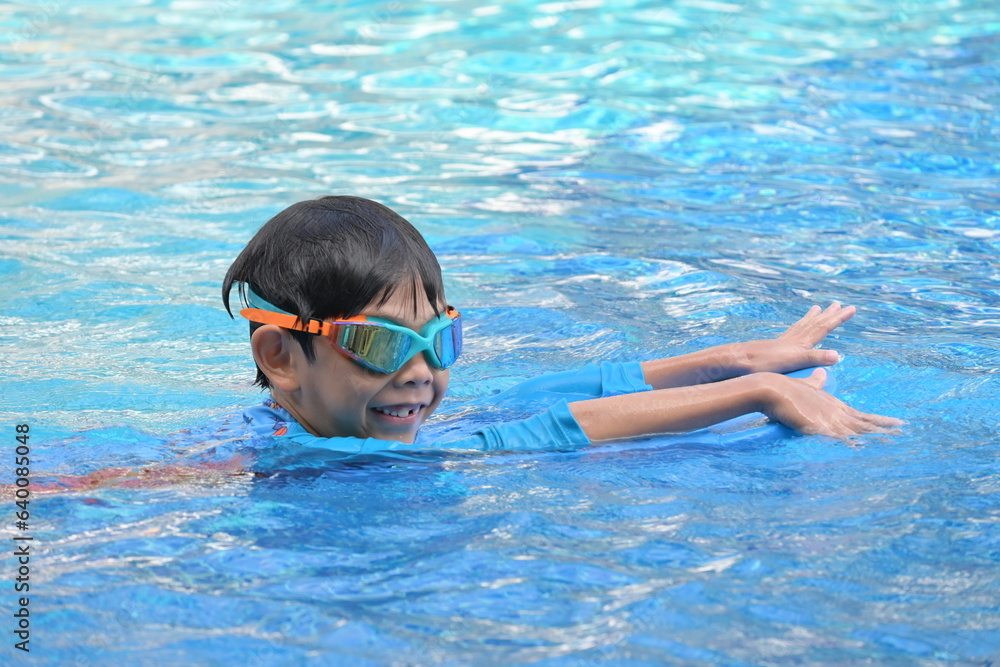 happy boy swimming in the blue pool, sport leisure activity