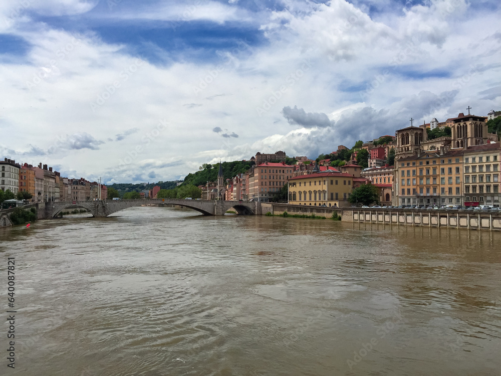 Fototapeta premium Scenic view of River Saone with Bonaparte Bridge and historical old town of Lyon, Auvergne-Rhone-Alpes, France, Europe. City walking tour on a cloudy day in summer. City tourism and landmarks