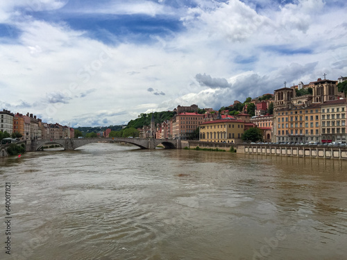 Scenic view of River Saone with Bonaparte Bridge and historical old town of Lyon, Auvergne-Rhone-Alpes, France, Europe. City walking tour on a cloudy day in summer. City tourism and landmarks